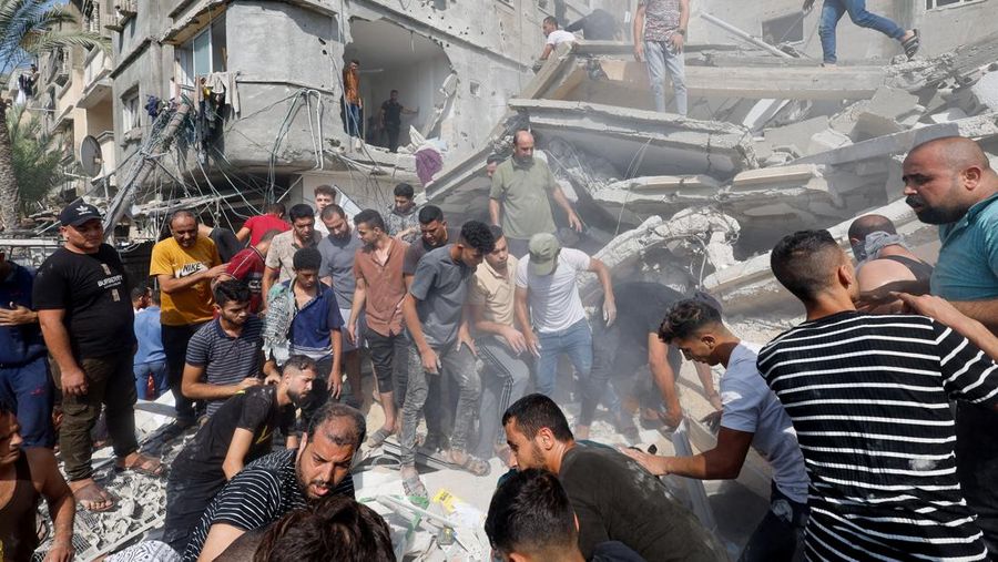 Warga Palestina berkumpul di lokasi serangan Israel terhadap sebuah rumah di Khan Younis, di Jalur Gaza selatan, 24 Oktober 2023. (REUTERS/Mohammed Salem)