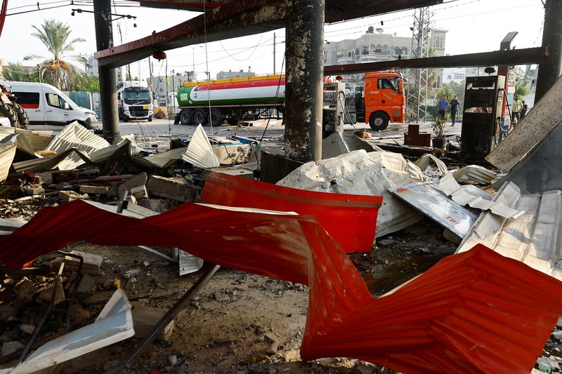Warga Palestina memeriksa pompa bensin yang terkena serangan Israel, di tengah konflik yang sedang berlangsung antara Israel dan kelompok Islam Palestina Hamas, di Khan Younis di selatan Jalur Gaza, 24 Oktober 2023. (REUTERS/Ibraheem Abu Mustafa)