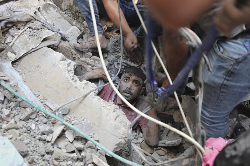 Warga Palestina berkumpul di lokasi serangan Israel terhadap sebuah rumah di Khan Younis, di Jalur Gaza selatan, 24 Oktober 2023. (REUTERS/Mohammed Salem)