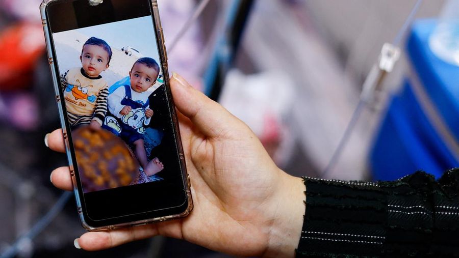 Gambar anak kembar Wateen dan Ahmed yang berusia 14 bulan ditampilkan di telepon saat Wateen beristirahat di rumah sakit Nasser setelah serangan Israel yang menewaskan ibunya dan melukai dirinya sendiri serta saudara kembarnya Ahmed, di Khan Younis, di Jalur Gaza selatan, 23 Oktober , 2023. (REUTERS/Mohammed Salem)