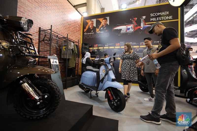 Pengunjung melihat motor listrik dalam ameran Indonesia Motorcycles Show atau IMOS+ 2023 di ICE BSD, Tangerang, Rabu (25/10/2023). (CNBC Indonesia/Tri Susilo)