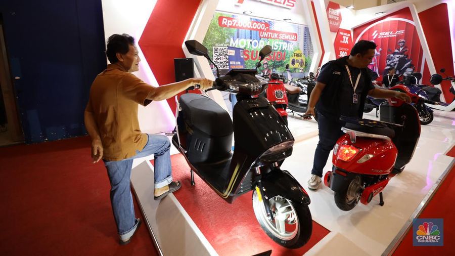 Pengunjung melihat motor listrik dalam ameran Indonesia Motorcycles Show atau IMOS+ 2023 di ICE BSD, Tangerang, Rabu (25/10/2023). (CNBC Indonesia/Tri Susilo)