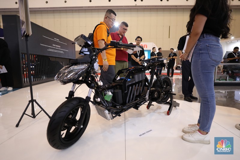 Pengunjung melihat motor listrik dalam ameran Indonesia Motorcycles Show atau IMOS+ 2023 di ICE BSD, Tangerang, Rabu (25/10/2023). (CNBC Indonesia/Tri Susilo)