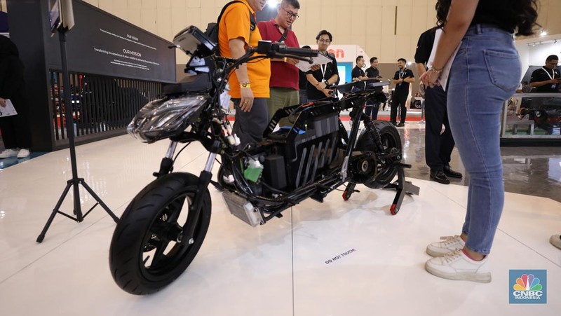Pengunjung melihat motor listrik dalam ameran Indonesia Motorcycles Show atau IMOS+ 2023 di ICE BSD, Tangerang, Rabu (25/10/2023). (CNBC Indonesia/Tri Susilo)