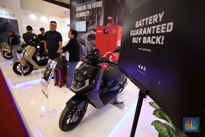Pengunjung melihat motor listrik dalam ameran Indonesia Motorcycles Show atau IMOS+ 2023 di ICE BSD, Tangerang, Rabu (25/10/2023). (CNBC Indonesia/Tri Susilo)