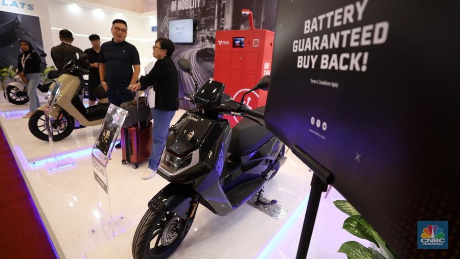 Pengunjung melihat motor listrik dalam ameran Indonesia Motorcycles Show atau IMOS+ 2023 di ICE BSD, Tangerang, Rabu (25/10/2023). (CNBC Indonesia/Tri Susilo)