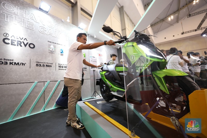 Pengunjung melihat motor listrik dalam ameran Indonesia Motorcycles Show atau IMOS+ 2023 di ICE BSD, Tangerang, Rabu (25/10/2023). (CNBC Indonesia/Tri Susilo)