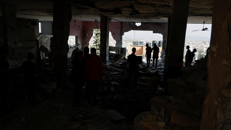 Warga Palestina memeriksa sisa-sisa masjid yang hancur akibat serangan Israel, saat konflik antara Israel dan kelompok Islam Palestina Hamas berlanjut, di Jalur Gaza utara 22 Oktober 2023. (REUTERS/Anas al-Shareef)
