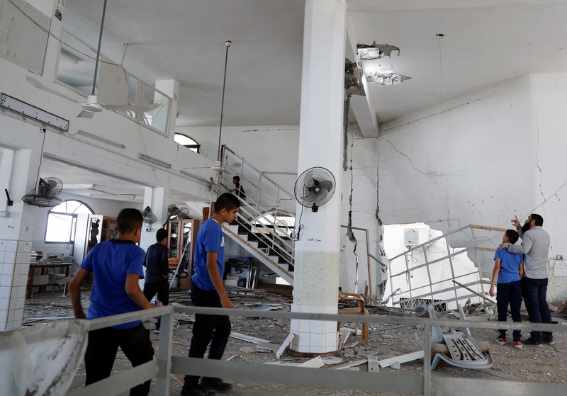 Warga Palestina memeriksa sisa-sisa masjid yang hancur akibat serangan Israel, saat konflik antara Israel dan kelompok Islam Palestina Hamas berlanjut, di Jalur Gaza utara 22 Oktober 2023. (REUTERS/Anas al-Shareef)