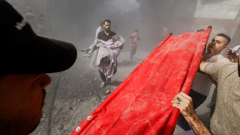 Warga Palestina bereaksi di lokasi serangan Israel terhadap rumah-rumah, ketika konflik antara Israel dan kelompok Islam Palestina Hamas berlanjut, di Khan Younis di selatan Jalur Gaza, 26 Oktober 2023. (REUTERS/Mohammed Salem)