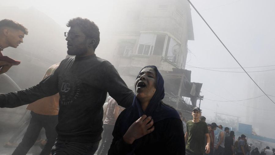 Warga Palestina bereaksi di lokasi serangan Israel terhadap rumah-rumah, ketika konflik antara Israel dan kelompok Islam Palestina Hamas berlanjut, di Khan Younis di selatan Jalur Gaza, 26 Oktober 2023. (REUTERS/Mohammed Salem)
