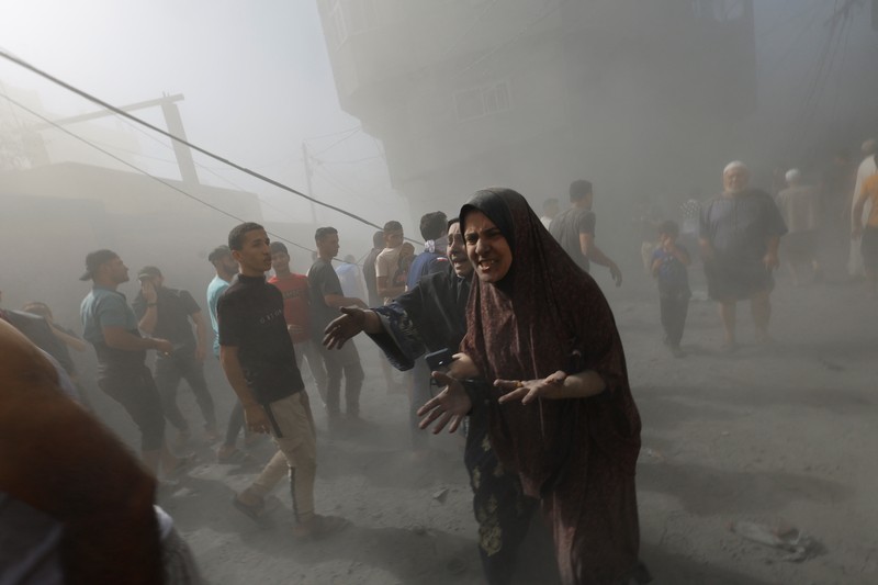 Warga Palestina bereaksi di lokasi serangan Israel terhadap rumah-rumah, ketika konflik antara Israel dan kelompok Islam Palestina Hamas berlanjut, di Khan Younis di selatan Jalur Gaza, 26 Oktober 2023. (REUTERS/Mohammed Salem)