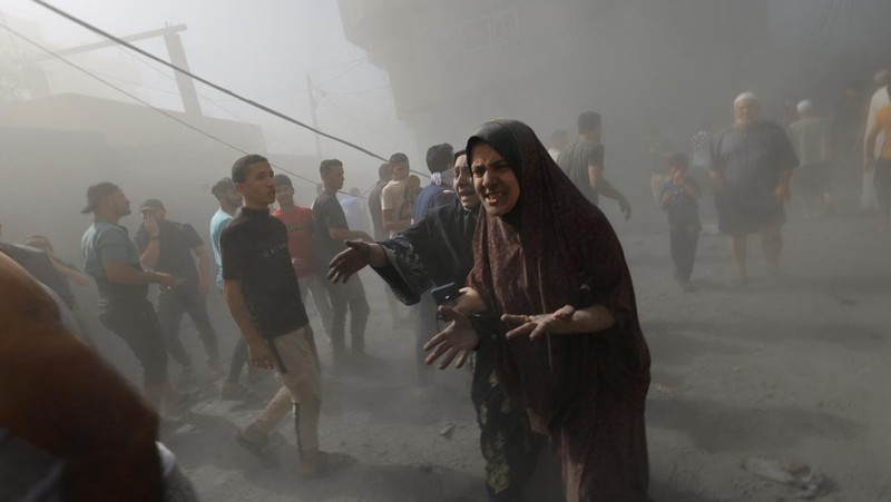 Warga Palestina bereaksi di lokasi serangan Israel terhadap rumah-rumah, ketika konflik antara Israel dan kelompok Islam Palestina Hamas berlanjut, di Khan Younis di selatan Jalur Gaza, 26 Oktober 2023. (REUTERS/Mohammed Salem)