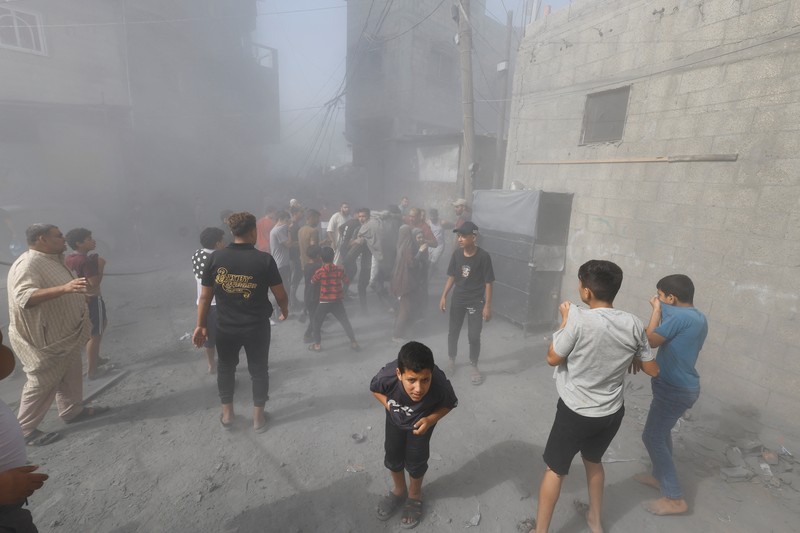 Warga Palestina bereaksi di lokasi serangan Israel terhadap rumah-rumah, ketika konflik antara Israel dan kelompok Islam Palestina Hamas berlanjut, di Khan Younis di selatan Jalur Gaza, 26 Oktober 2023. (REUTERS/Mohammed Salem)