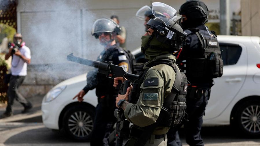 Seorang petugas polisi perbatasan Israel menembakkan tabung gas pengendali massa, ketika warga Muslim Palestina mencoba mengadakan shalat Jumat di jalan di luar Kota Tua Yerusalem, ketika konflik antara Israel dan kelompok Islam Palestina Hamas berlanjut, di Yerusalem, 27 Oktober 2023 . (REUTERS/Ammar Awad)