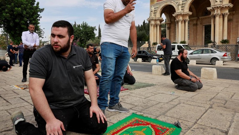 Warga Muslim Palestina mengadakan salat Jumat di jalan di luar Kota Tua Yerusalem, saat konflik antara Israel dan kelompok Islam Palestina Hamas berlanjut, di Yerusalem, 27 Oktober 2023. (REUTERS/Ammar Awad)