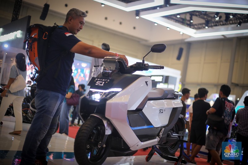 Seorang pengunjung melihat motor listrik Savart S-1 dalam Gelaran Indonesia Motorcycle Show Plus (IMOS+) 2023. (CNBC Indonesia/Tias Budiarto)