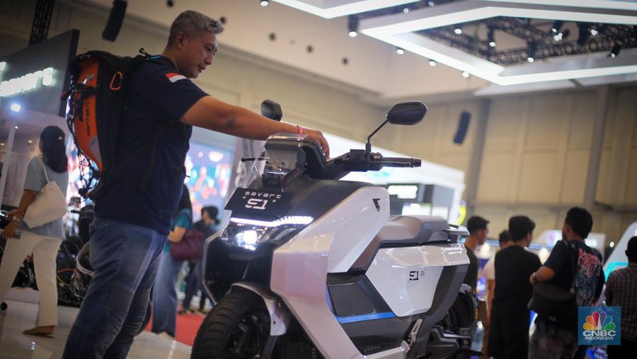 Seorang pengunjung melihat motor listrik Savart S-1 dalam Gelaran Indonesia Motorcycle Show Plus (IMOS+) 2023. (CNBC Indonesia/Tias Budiarto)