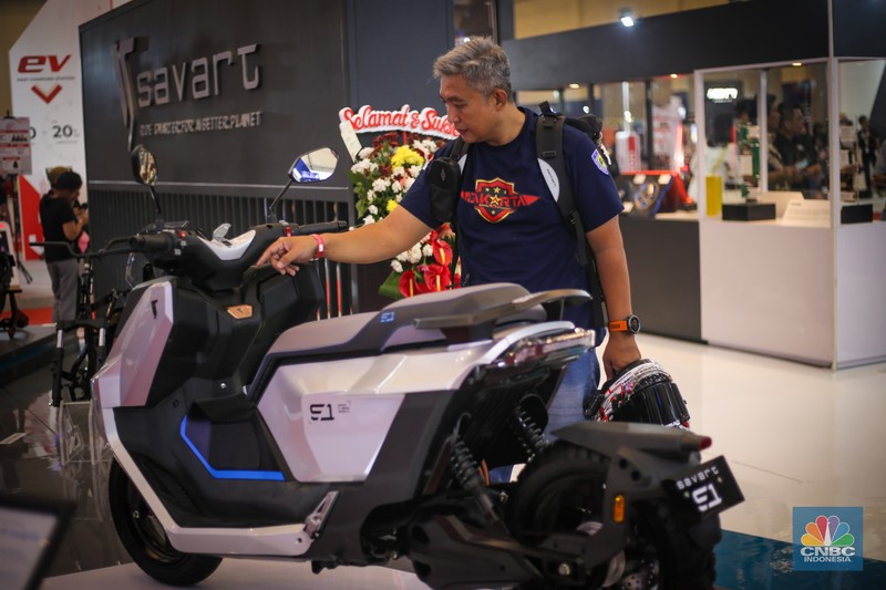 Seorang pengunjung melihat motor listrik Savart S-1 dalam Gelaran Indonesia Motorcycle Show Plus (IMOS+) 2023. (CNBC Indonesia/Tias Budiarto)