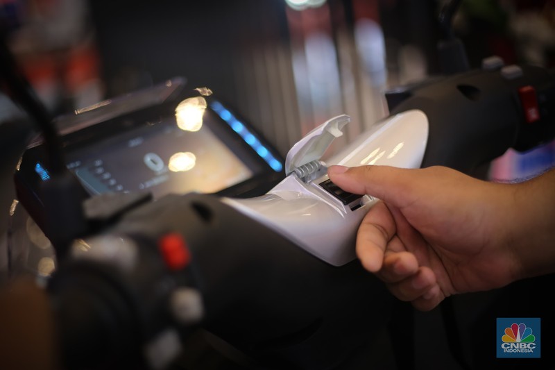 Seorang pengunjung melihat motor listrik Savart S-1 dalam Gelaran Indonesia Motorcycle Show Plus (IMOS+) 2023. (CNBC Indonesia/Tias Budiarto)