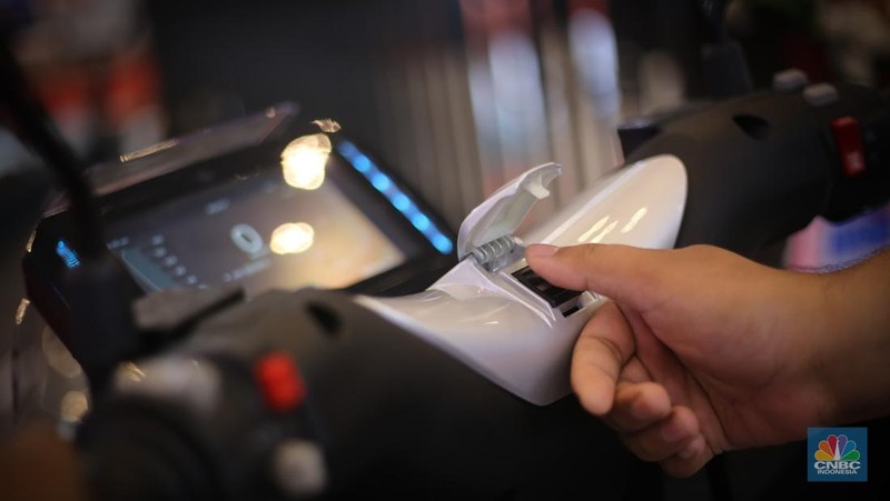 Seorang pengunjung melihat motor listrik Savart S-1 dalam Gelaran Indonesia Motorcycle Show Plus (IMOS+) 2023. (CNBC Indonesia/Tias Budiarto)