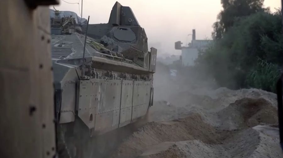 Kendaraan lapis baja Pasukan Pertahanan Israel (IDF) menunggu saat buldoser lapis baja membersihkan jalan yang dipenuhi puing-puing di lokasi yang disebut sebagai Gaza, saat konflik antara Israel dan kelompok Islam Palestina Hamas terus berlanjut, dalam tangkapan layar yang diperoleh dari video selebaran yang dirilis di 29 Oktober 2023. (Israeli Defence Forces/Handout via REUTERS)