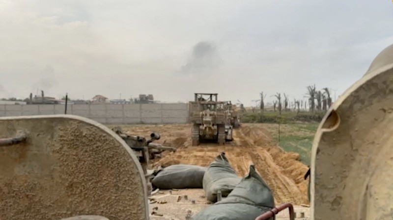 Kendaraan lapis baja Pasukan Pertahanan Israel (IDF) menunggu saat buldoser lapis baja membersihkan jalan yang dipenuhi puing-puing di lokasi yang disebut sebagai Gaza, saat konflik antara Israel dan kelompok Islam Palestina Hamas terus berlanjut, dalam tangkapan layar yang diperoleh dari video selebaran yang dirilis di 29 Oktober 2023. Kendaraan lapis baja Pasukan Pertahanan Israel (IDF) menunggu saat buldoser lapis baja membersihkan jalan yang dipenuhi puing-puing di lokasi yang disebut sebagai Gaza, saat konflik antara Israel dan kelompok Islam Palestina Hamas terus berlanjut, dalam tangkapan layar yang diperoleh dari video selebaran yang dirilis di 29 Oktober 2023. (Israeli Defence Forces/Handout via REUTERS)