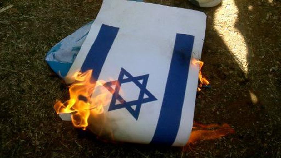 Lebanese and Palestinian students burn a copy of the Israeli flag during a solidarity rally with the Palestinians of the Gaza Strip, in Martyrs' Square in the coastal city of Sidon, in southern Lebanon on October 26, 2023, amid the ongoing battles between Israel and the Palestinian group Hamas. Thousands of civilians, both Palestinians and Israelis, have died since October 7, 2023, after Palestinian Hamas militants based in the Gaza Strip entered southern Israel in an unprecedented attack triggering a war declared by Israel on Hamas with retaliatory bombings on Gaza. (Photo by Mahmoud ZAYYAT / AFP)