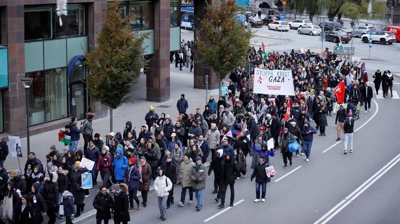 Seorang pengunjuk rasa pro-Palestina memegang kain putih dibuat menyerupai anak yang meninggal saat demonstrasi di Ottawa, Ontario, Minggu, 22 Oktober 2023. (Spencer Colby/The Canadian Press via AP)