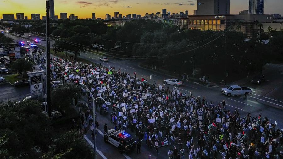 Seorang pengunjuk rasa pro-Palestina memegang kain putih dibuat menyerupai anak yang meninggal saat demonstrasi di Ottawa, Ontario, Minggu, 22 Oktober 2023. (Spencer Colby/The Canadian Press via AP)