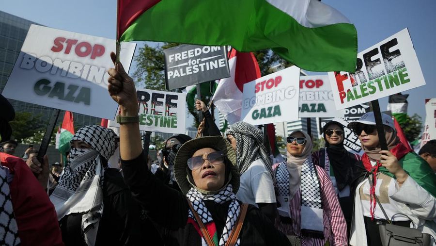 Seorang pengunjuk rasa pro-Palestina memegang kain putih dibuat menyerupai anak yang meninggal saat demonstrasi di Ottawa, Ontario, Minggu, 22 Oktober 2023. (Spencer Colby/The Canadian Press via AP)