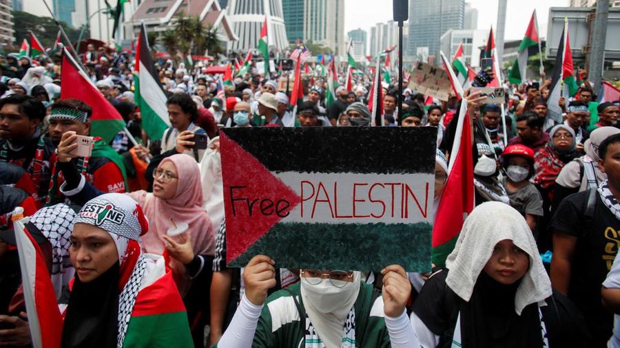 Seorang pengunjuk rasa pro-Palestina memegang kain putih dibuat menyerupai anak yang meninggal saat demonstrasi di Ottawa, Ontario, Minggu, 22 Oktober 2023. (Spencer Colby/The Canadian Press via AP)