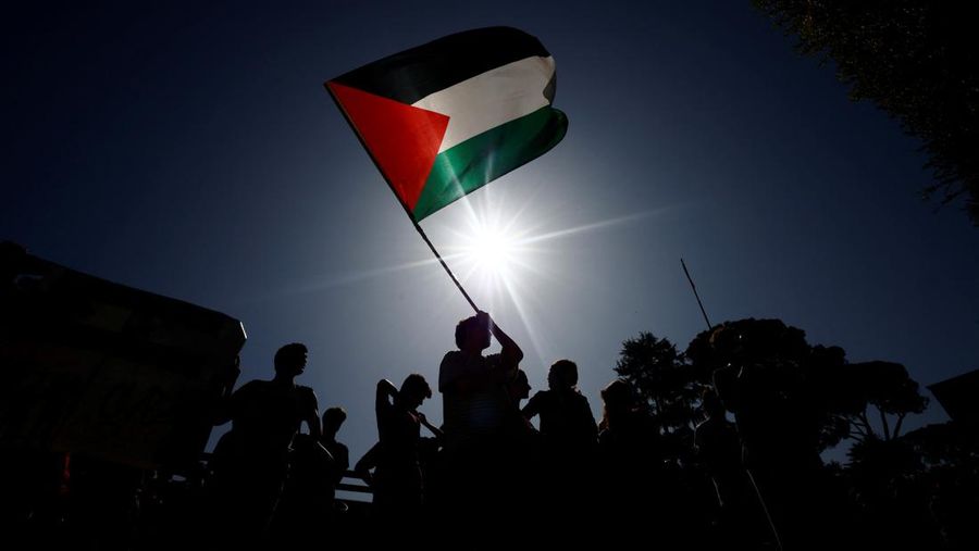 Seseorang memegang bendera Palestina saat mahasiswa berdemonstrasi untuk menyatakan dukungan kepada rakyat Palestina selama protes di Universitas La Sapienza, di Roma, (REUTERS/Yara Nardi)