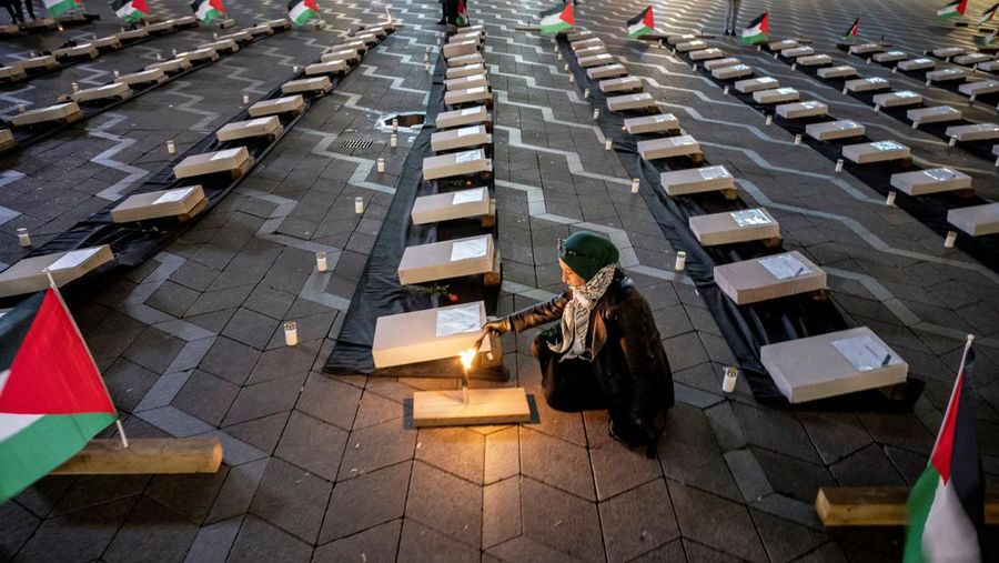 Seorang pengunjuk rasa pro-Palestina memegang kain putih dibuat menyerupai anak yang meninggal saat demonstrasi di Ottawa, Ontario, Minggu, 22 Oktober 2023. (Spencer Colby/The Canadian Press via AP)