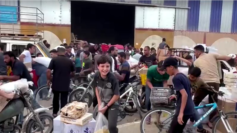 Warga Palestina menyerbu gudang PBB untuk mendapatkan pasokan makanan. (Tangkapan Layar Reuters Video)
