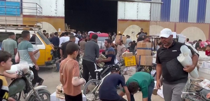 Warga Palestina menyerbu gudang PBB untuk mendapatkan pasokan makanan. (Tangkapan Layar Reuters Video) Warga Palestina menyerbu gudang PBB untuk mendapatkan pasokan makanan. (Tangkapan Layar Reuters Video)