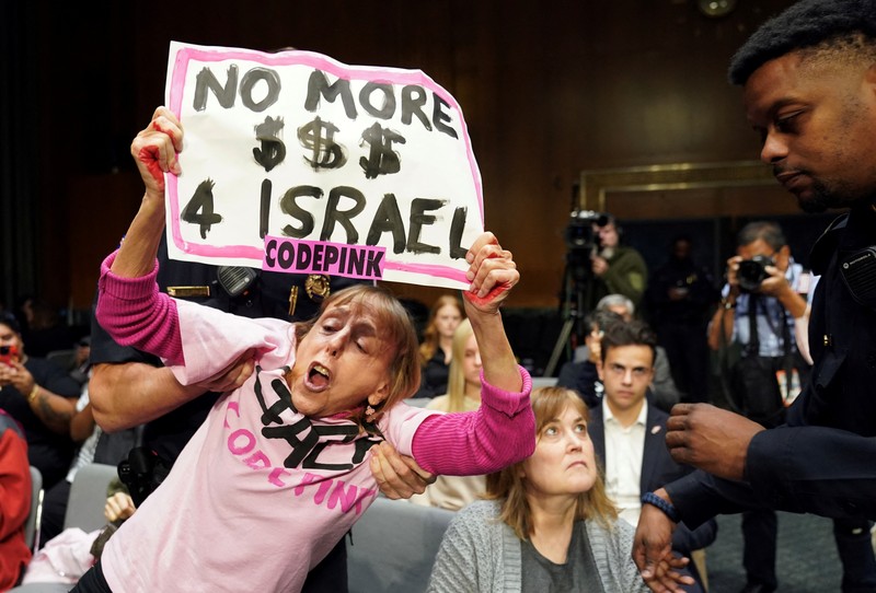 Anti-war protesters raise their  “bloody” hands behind U.S. Secretary of State Antony Blinken during a Senate Appropriations Committee hearing on President Biden's $106 billion national security supplemental funding request to support Israel and Ukraine, as well as bolster border security, on Capitol Hill in Washington, U.S., October 31, 2023. REUTERS/Kevin Lamarque