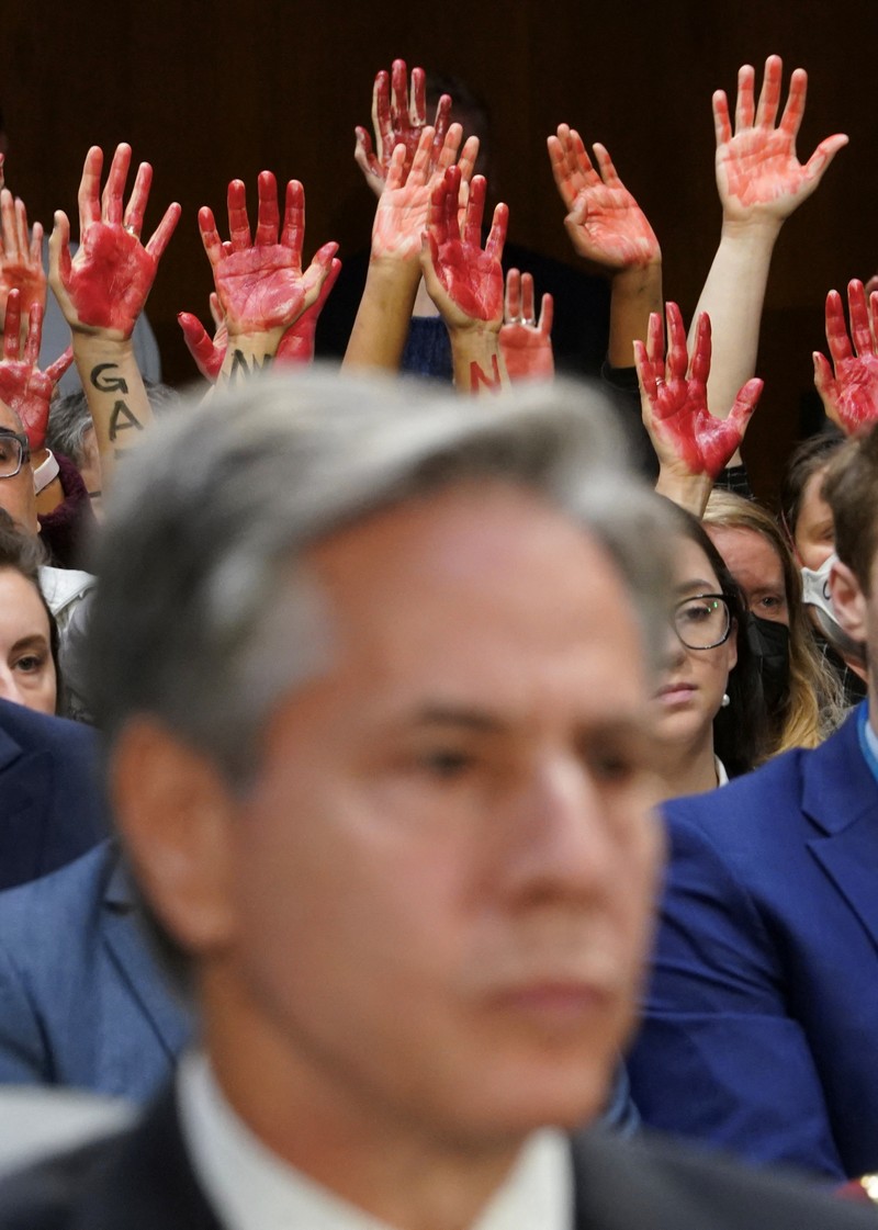 Anti-war protesters raise their  “bloody” hands behind U.S. Secretary of State Antony Blinken during a Senate Appropriations Committee hearing on President Biden's $106 billion national security supplemental funding request to support Israel and Ukraine, as well as bolster border security, on Capitol Hill in Washington, U.S., October 31, 2023. REUTERS/Kevin Lamarque