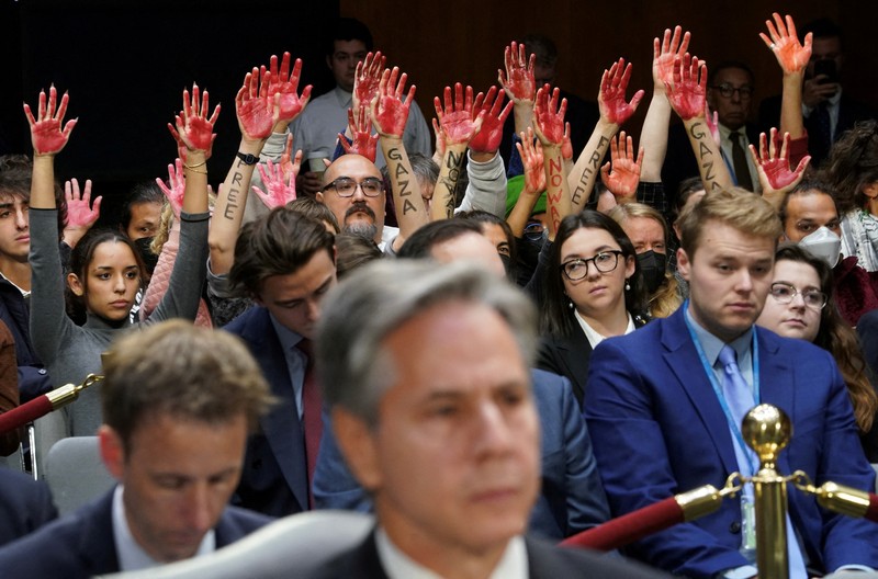 Anti-war protesters raise their  “bloody” hands behind U.S. Secretary of State Antony Blinken during a Senate Appropriations Committee hearing on President Biden's $106 billion national security supplemental funding request to support Israel and Ukraine, as well as bolster border security, on Capitol Hill in Washington, U.S., October 31, 2023. REUTERS/Kevin Lamarque