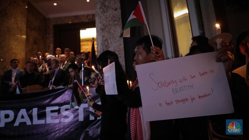 Sejumlah elemen masyarakat menyalakan lilin melakukan doa bersama saat mengikuti aksi damai Bela Palestina di Kedutaan Besar (Kedubes) Palestina, Jakarta, Kamis (2/11/2023) malam. (CNBC Indonesia/Faisal Rahman)