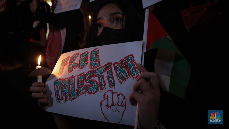 Sejumlah elemen masyarakat menyalakan lilin melakukan doa bersama saat mengikuti aksi damai Bela Palestina di Kedutaan Besar (Kedubes) Palestina, Jakarta, Kamis (2/11/2023) malam. (CNBC Indonesia/Faisal Rahman)