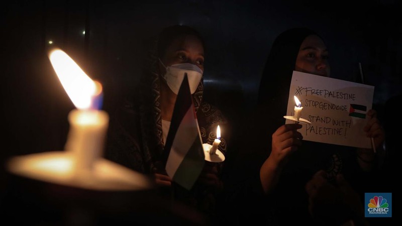 Sejumlah elemen masyarakat menyalakan lilin melakukan doa bersama saat mengikuti aksi damai Bela Palestina di Kedutaan Besar (Kedubes) Palestina, Jakarta, Kamis (2/11/2023) malam. (CNBC Indonesia/Faisal Rahman)
