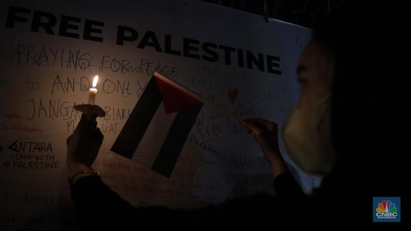 Sejumlah elemen masyarakat menyalakan lilin melakukan doa bersama saat mengikuti aksi damai Bela Palestina di Kedutaan Besar (Kedubes) Palestina, Jakarta, Kamis (2/11/2023) malam. (CNBC Indonesia/Faisal Rahman)