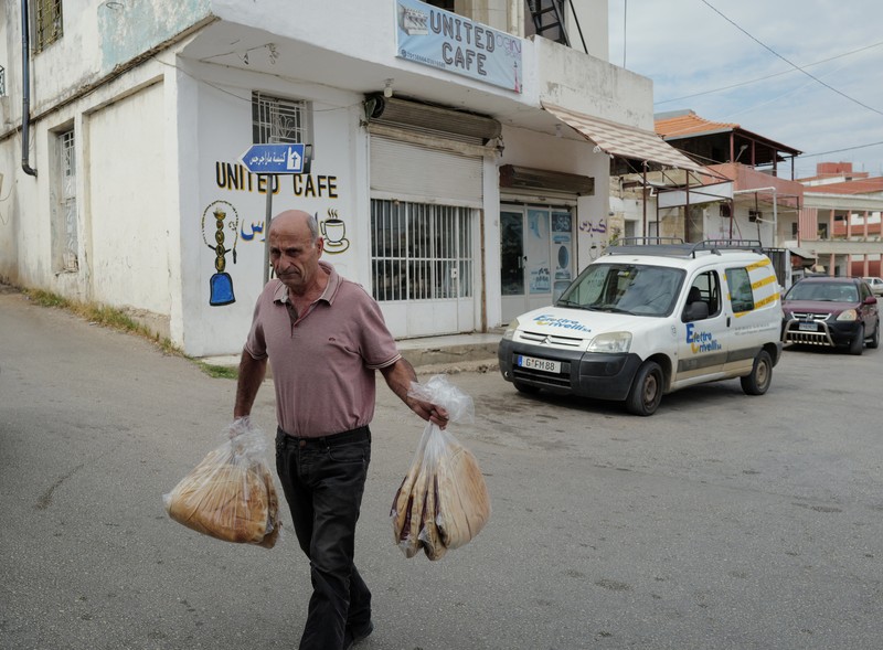 Seorang pria membawa kantong roti untuk dijual, di tengah ketegangan antara Israel dan Hizbullah, di desa Kristen Rmeish, Lebanon 31 Oktober 2023. (REUTERS/Zohra Bensemra)