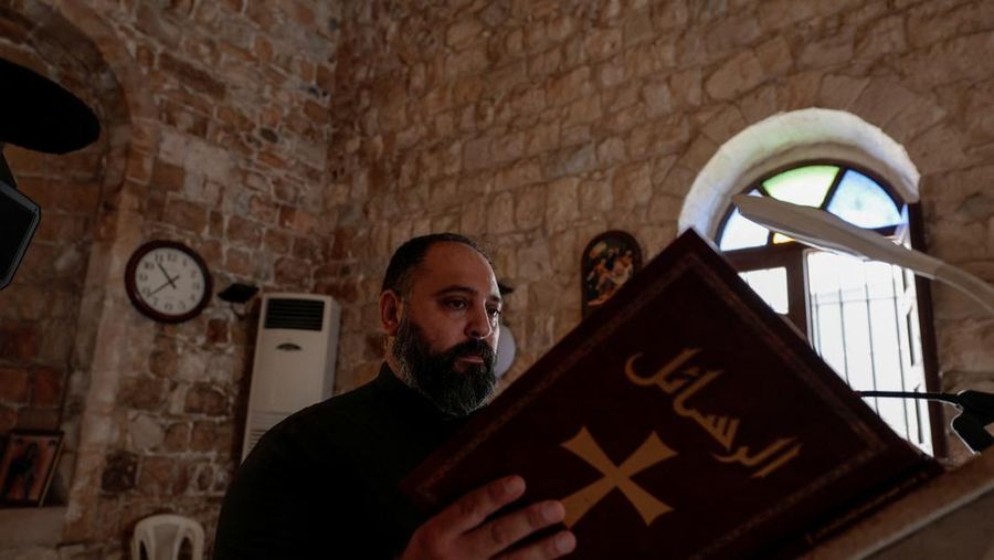 Toni Elias, 40, pendeta dari desa Kristen Rmeish membaca, di tengah ketegangan antara Israel dan Hizbullah, di gereja Saint George di desa Selatan Rmeish, Lebanon 31 Oktober 2023. (REUTERS/Zohra Bensemra)