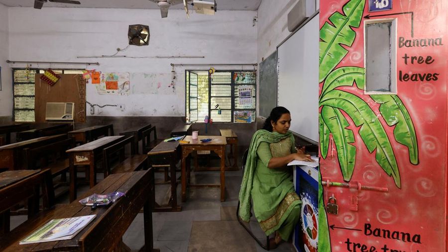 Para guru melakukan kelas online menggunakan ponsel setelah sekolah dasar diperintahkan ditutup oleh pemerintah Delhi pada hari Jumat dan Sabtu karena indeks kualitas udara (AQI) anjlok, pada pagi yang berkabut di New Delhi, India, 3 November 2023. (REUTERS/Anushree Fadnavis)