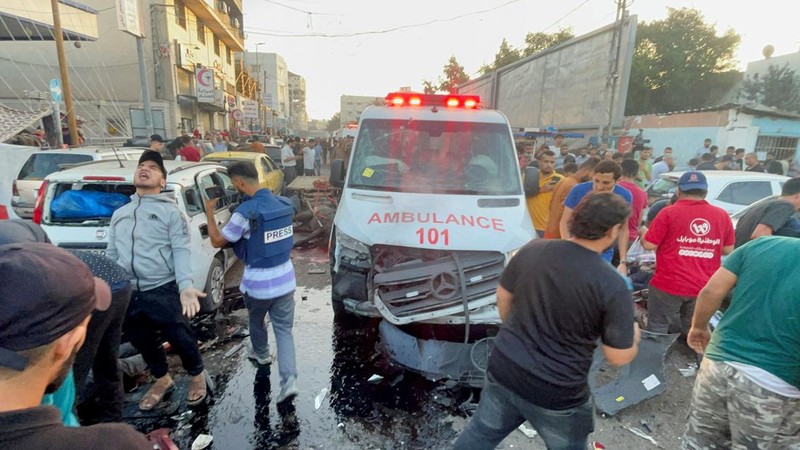 Warga Palestina memeriksa kerusakan setelah konvoi ambulans dihantam, di pintu masuk rumah sakit Shifa di Kota Gaza, 3 November 2023. (REUTERS/Mohammed Al-Masri)