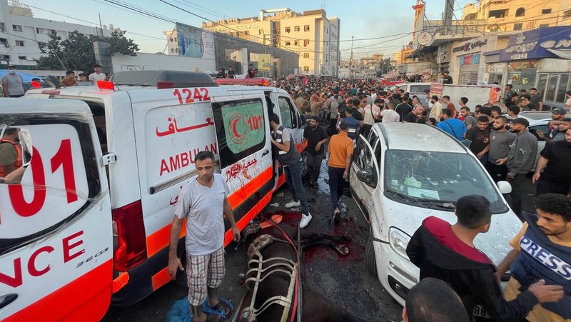 Warga Palestina memeriksa kerusakan setelah konvoi ambulans dihantam, di pintu masuk rumah sakit Shifa di Kota Gaza, 3 November 2023. (REUTERS/Mohammed Al-Masri)