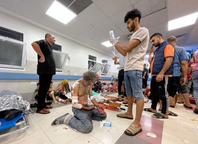 Warga Palestina memeriksa kerusakan setelah konvoi ambulans dihantam, di pintu masuk rumah sakit Shifa di Kota Gaza, 3 November 2023. (REUTERS/Mohammed Al-Masri)