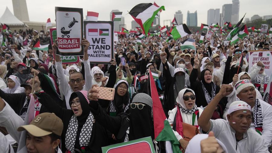 Protesters shout slogans and wave Palestinian flags during a rally in support of the Palestinians in Gaza, at the National Monument in Jakarta, Indonesia, Sunday, Nov. 5, 2023. (AP Photo/Dita Alangkara)